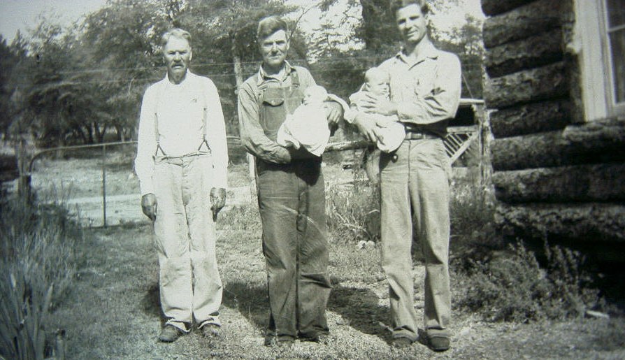 Four generations of Waldrip men standing outside the pioneer log cabin