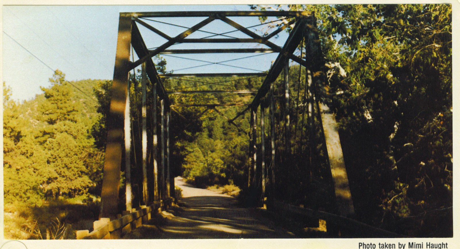 Steel through-truss bridge framing a single-lane road in Young, Arizona
